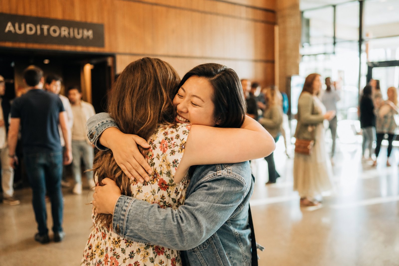 Two women embracing in a church lobby after a service