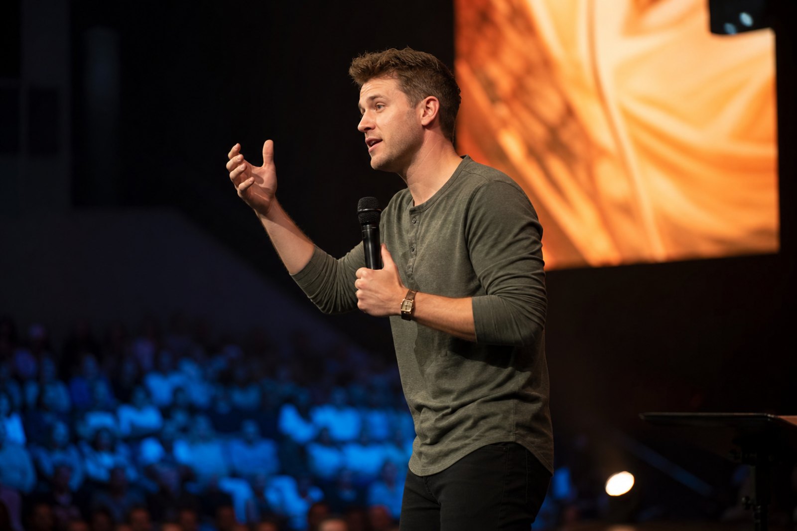 A pastor speaking to a congregation in warm light